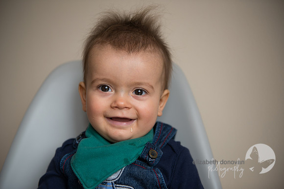 cheeky little boy sitting on a chair Baby photo shoot in the home natural photography with little one family lifestyle swindon wiltshire