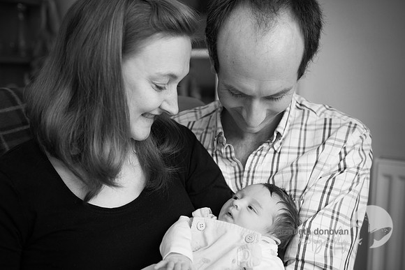 mum and dad looking at their new born baby girl Baby photo shoot in the home natural photography with little one family lifestyle swindon wiltshire