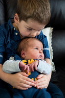 brother gives his baby brother a tender kiss Baby photo shoot in the home natural photography with little one family lifestyle swindon wiltshire