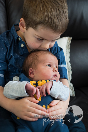 brother gives his baby brother a tender kiss Baby photo shoot in the home natural photography with little one family lifestyle swindon wiltshire