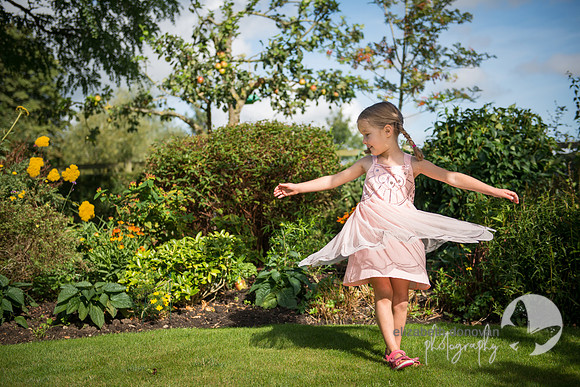 summer photo shoot in family garden in wiltshire girl playing spinning elizabeth donovan photography