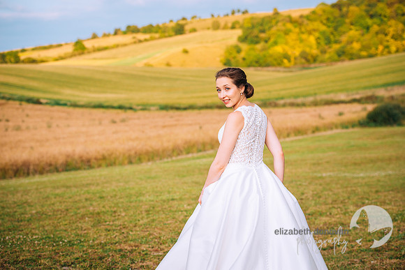 bride looking at the camera with incredible hill behind her, golden hour wedding photograph elizabeth donovan photography